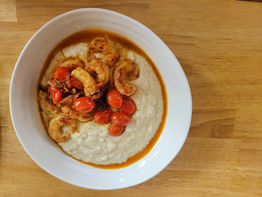 wood table with white bowl with grits and shrimp