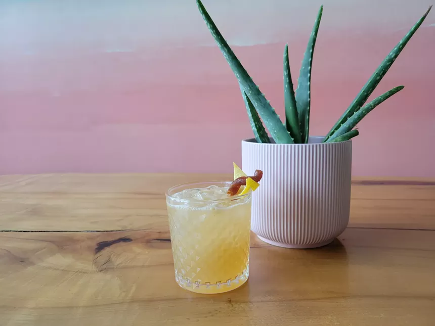 drink on wooden table with plant and pink wall