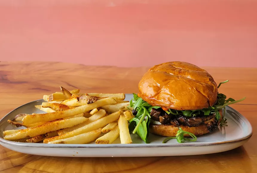 fries and burger on plate with pink background