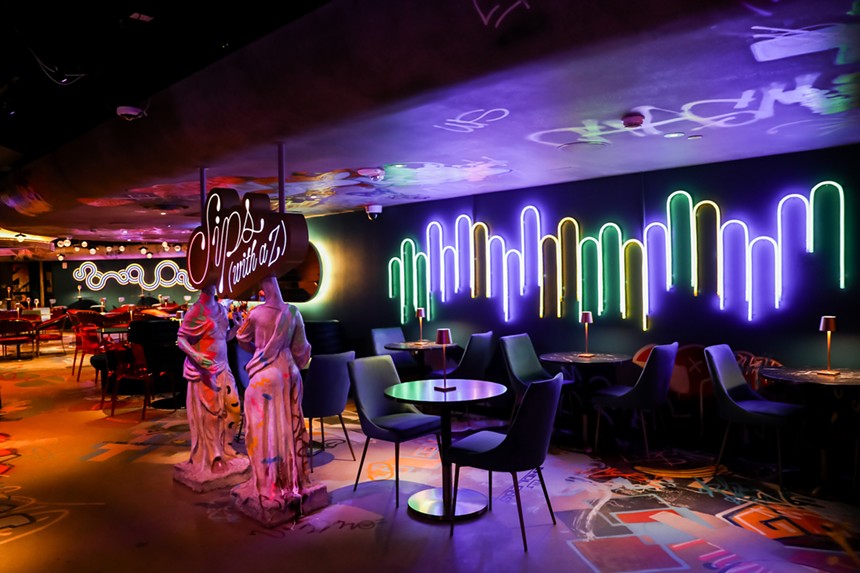 a bar with graffiti and neon art installations
