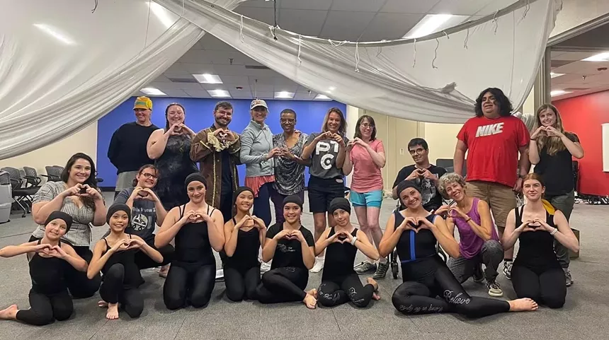 a team of actors making a heart shape with their hands