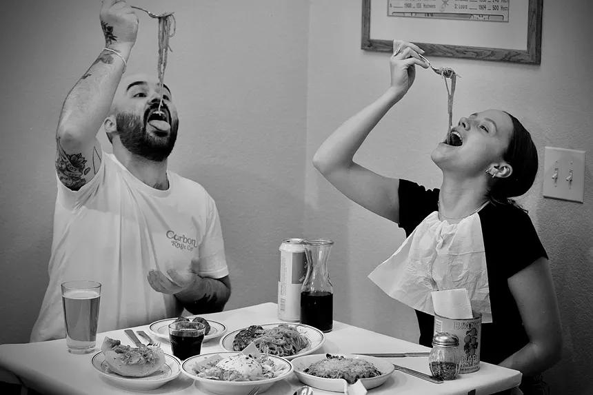 two people sitting at a table eating food