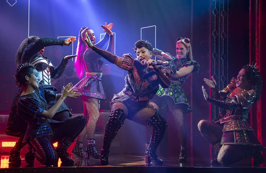 women singing on stage with purple lights
