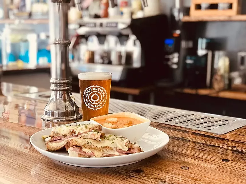 food on a plate in front of a glass of beer