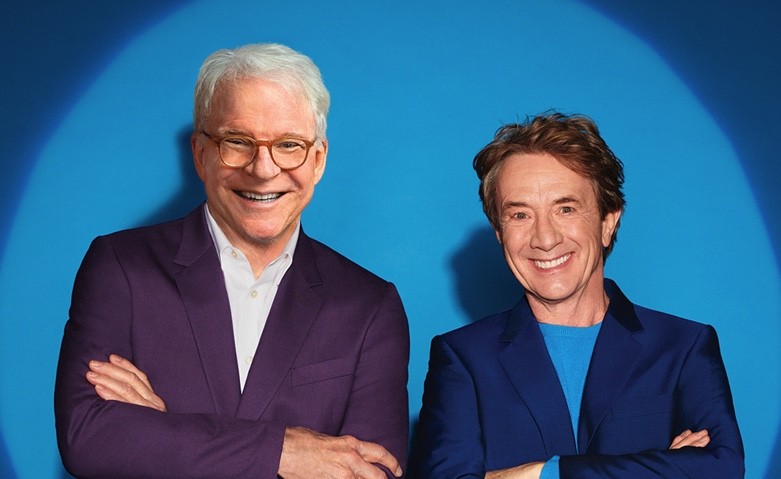 steve martin in a white shirt and purple jacket and martin short in a blue shirt and jacket