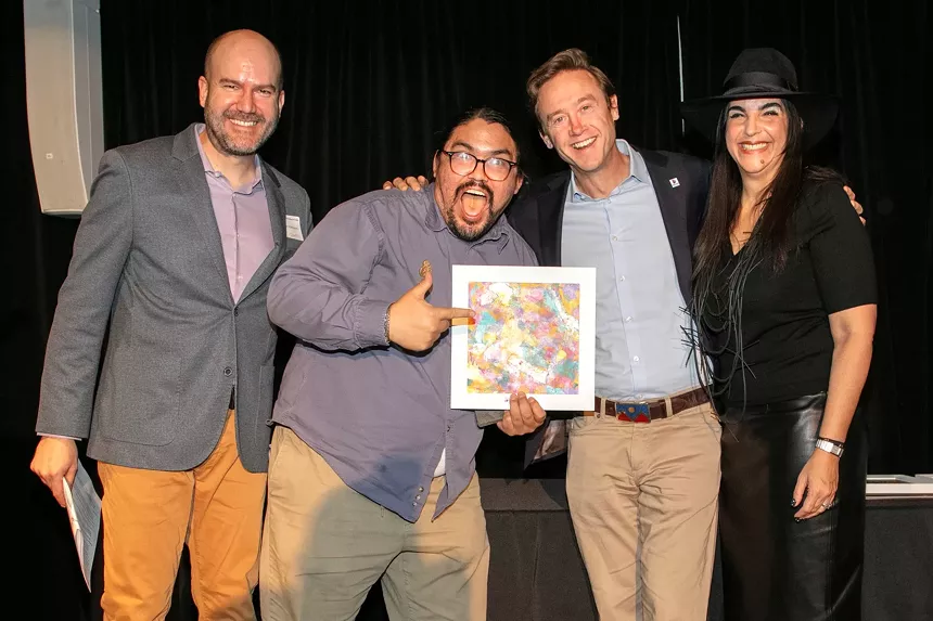 man taking award with three other men around