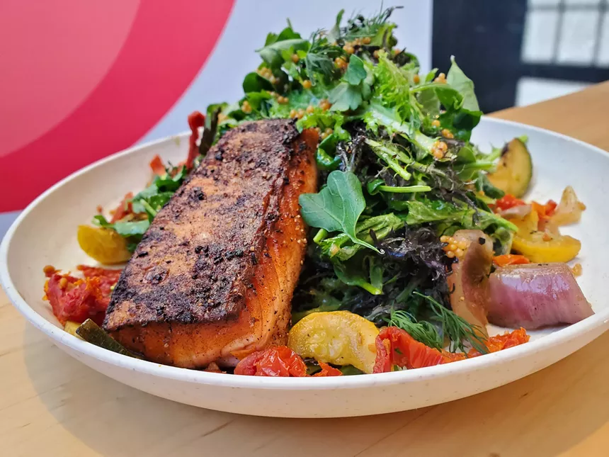 a salad with a piece of salmon