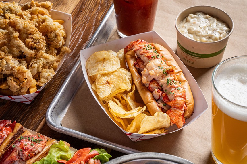lobster roll with chips in paper basket on tray