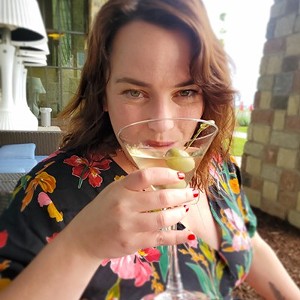 Woman with brown hair drinking a martini