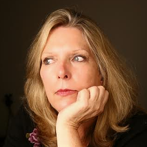 Woman with shoulder length blonde hair looks to the left with her hand on her chin