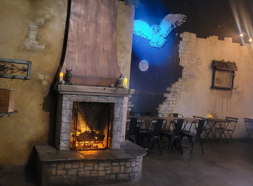 fire place and owl flying at night by tables and chairs