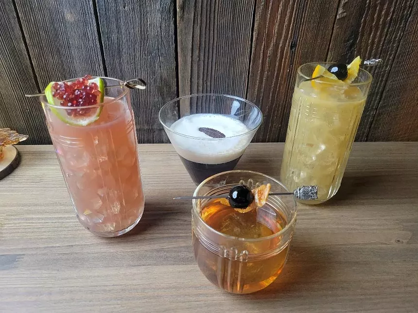 wooden table with four cocktails on it