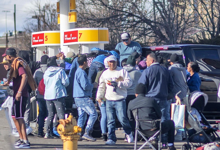 men gathered by gas station