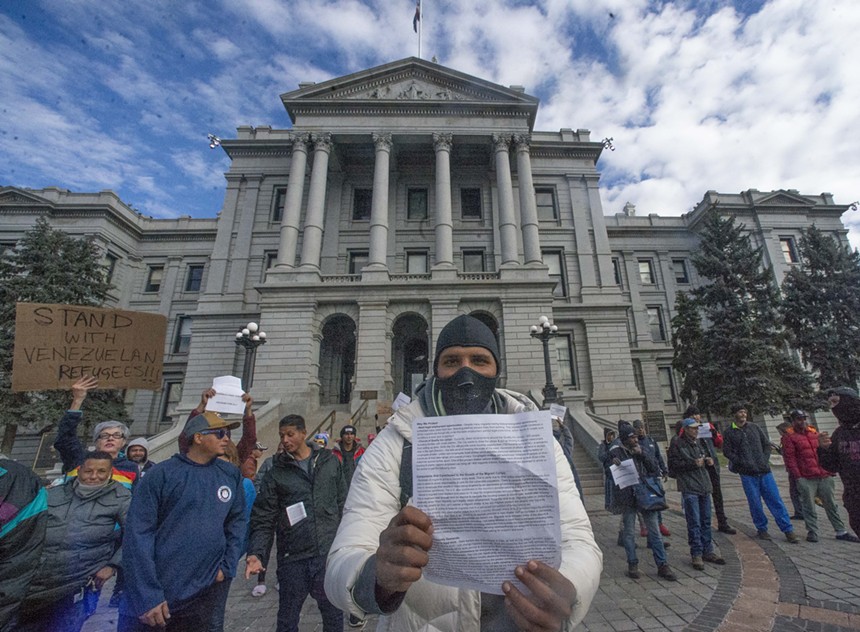 man holding paper in front of Colorado Capitol.