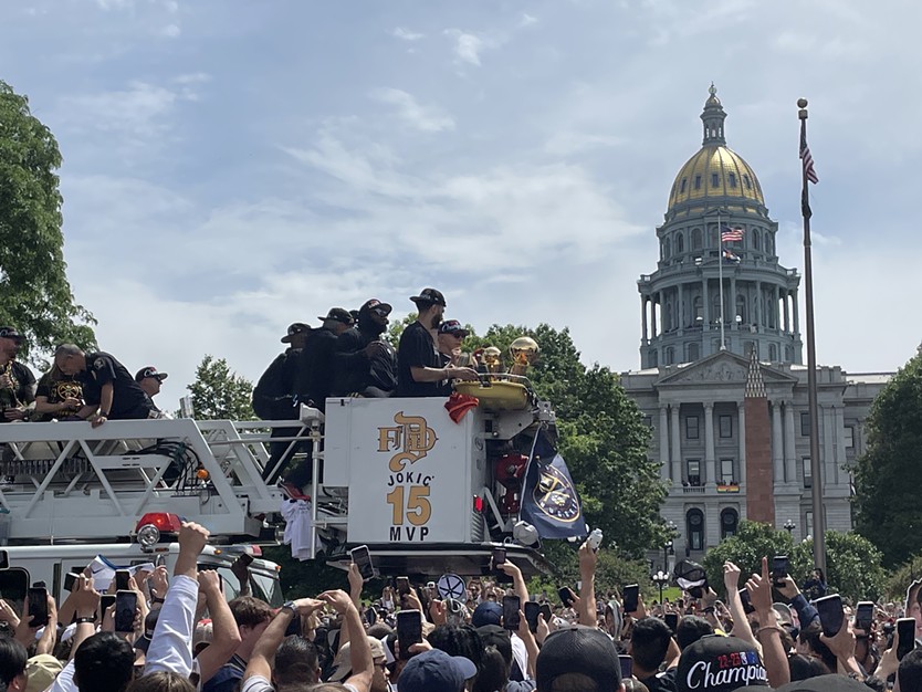 Men ride in a firetruck on parade.