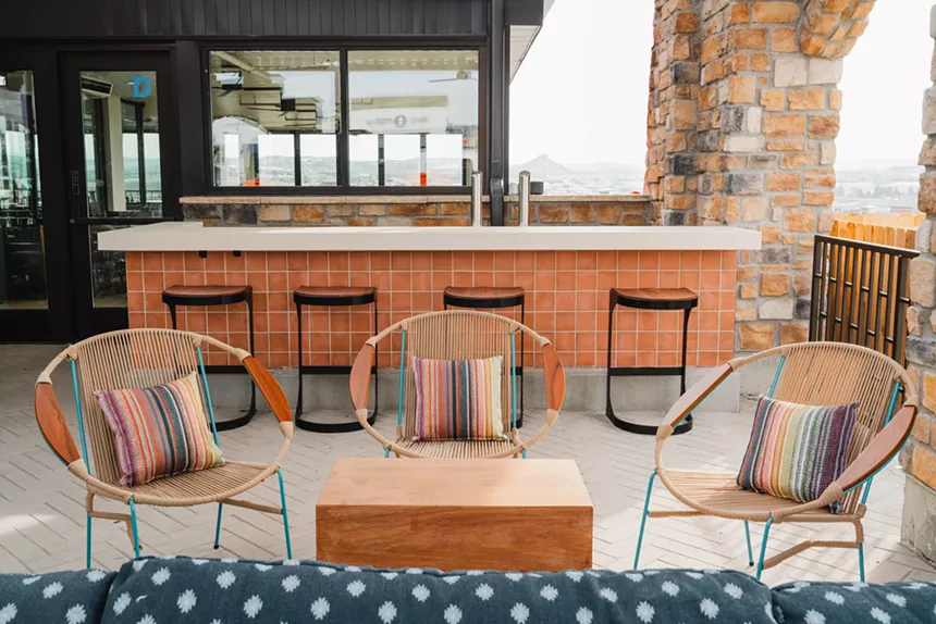 chairs, a table and a bar on a patio