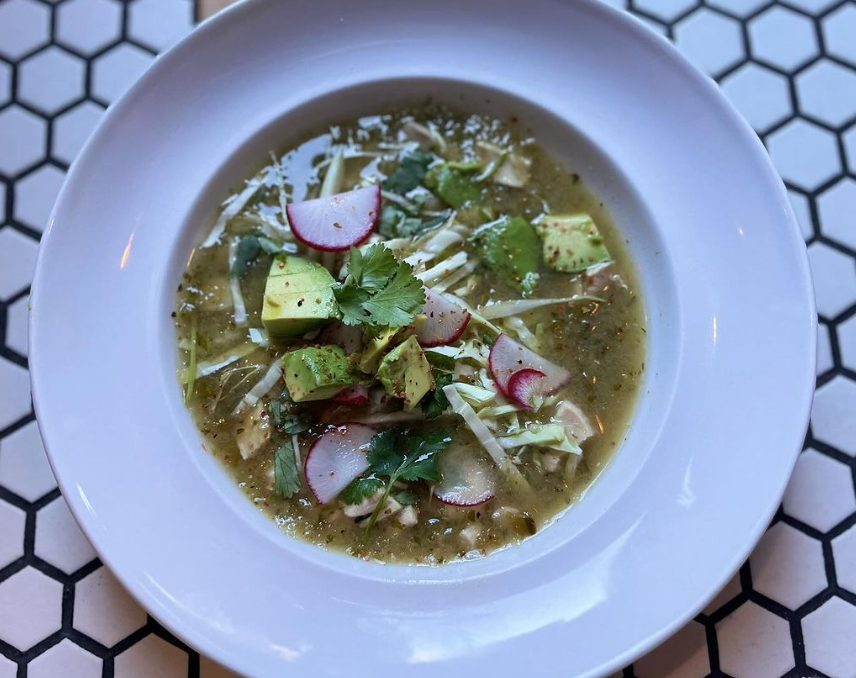 a bowl of soup topped with radish and avocado