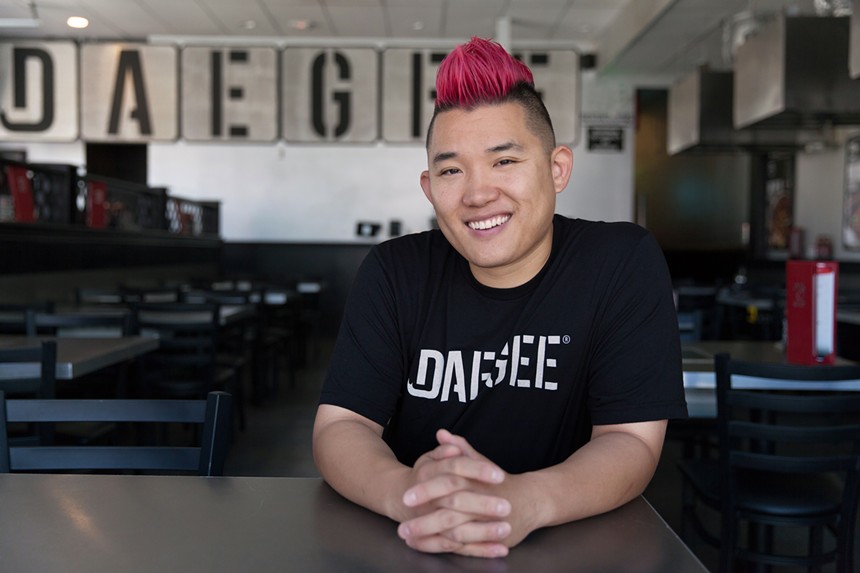 a man with a pink mohawk posting in a black t shirt