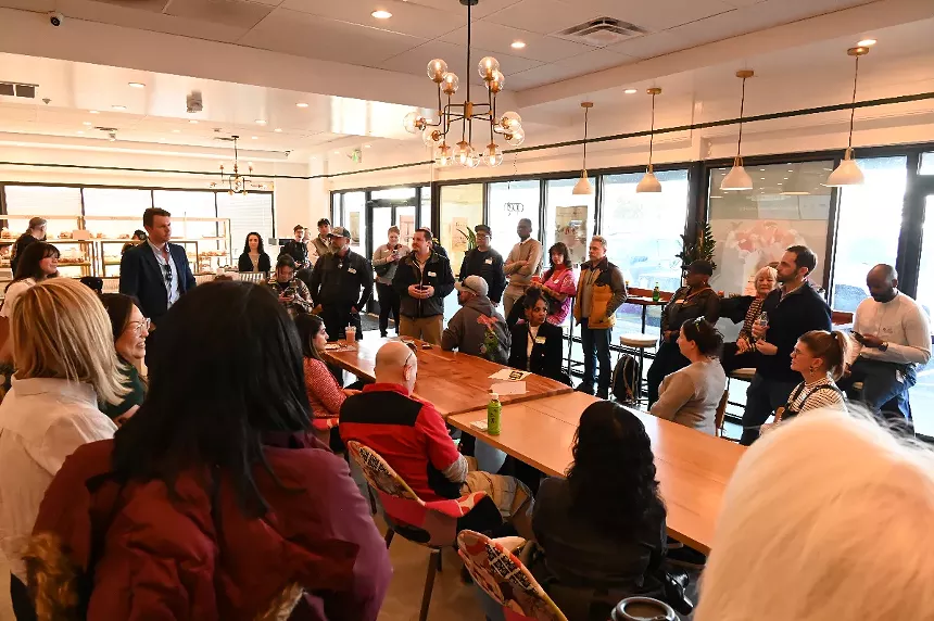 Colin Larson with the Colorado Restaurant Association speaks in a crowded area.