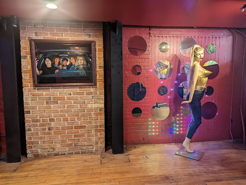 a madonna mannequin next to a framed photo