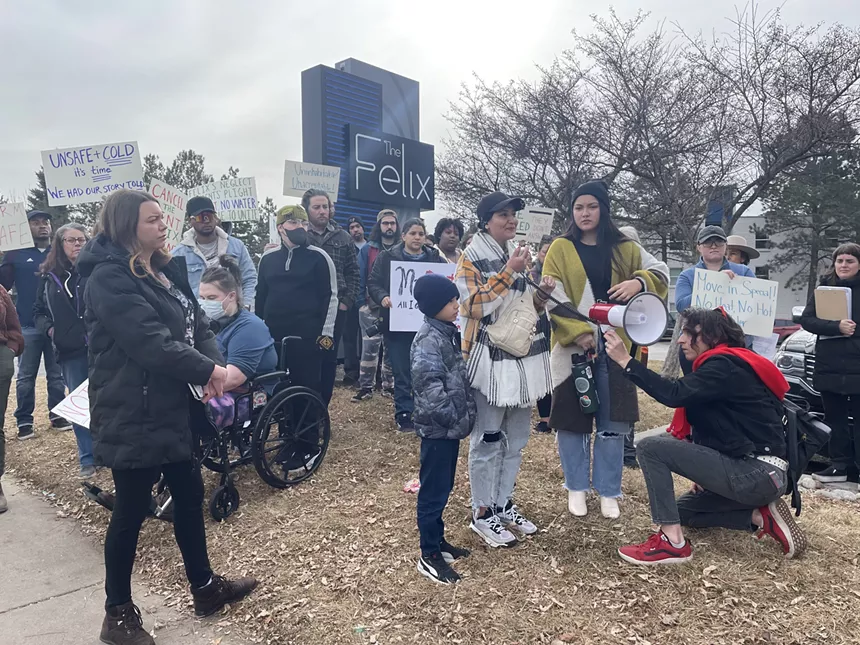 A woman with a child speaks into a megaphone.