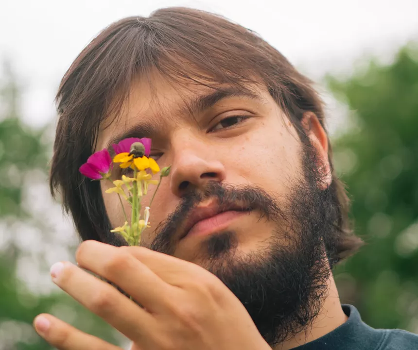 man holding a wildflower