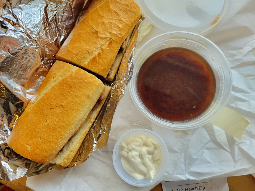 French dip sandwich on white paper with sauce