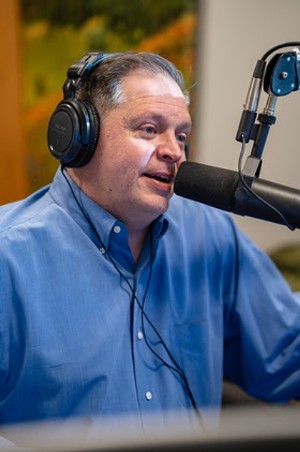 man in blue shirt talking on radio