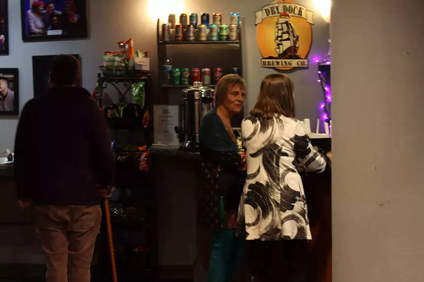 three people standing at a bar