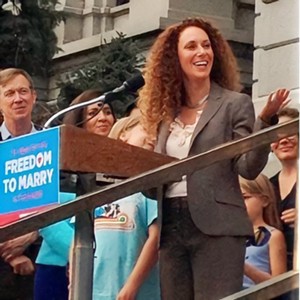 woman at podium at political rally.