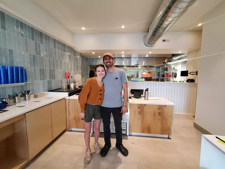 a woman and a man standing inside a restaurant
