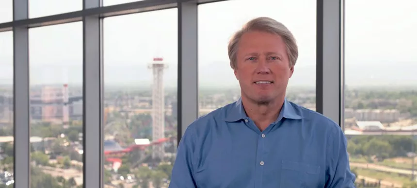 man in blue shirt in front of window