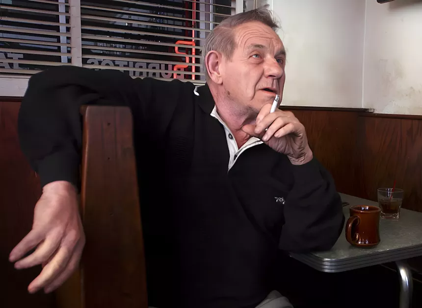 man in booth with cigarette