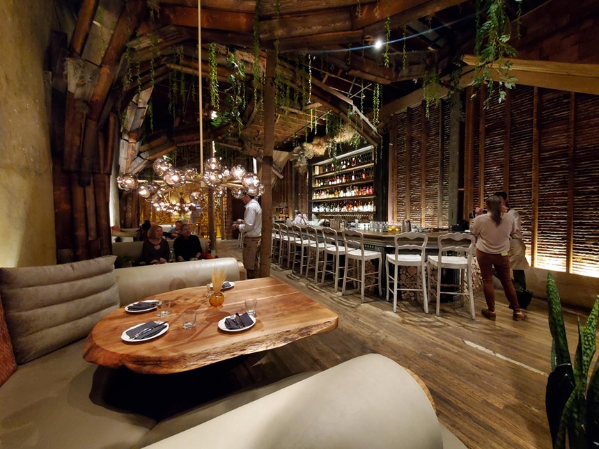 interior of a restaurant with a bar and forest-themed decor