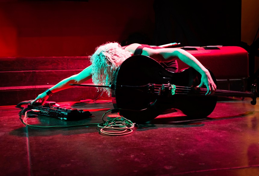 woman bowing next to a cello