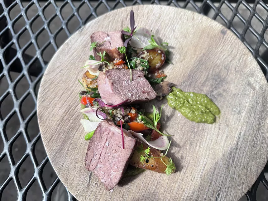 slices of steak on a plate with vegetables