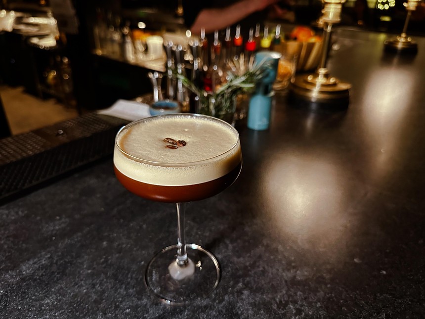 brown martini sits on a bar