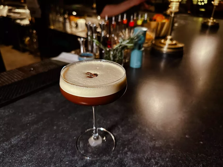 brown martini sits on a bar