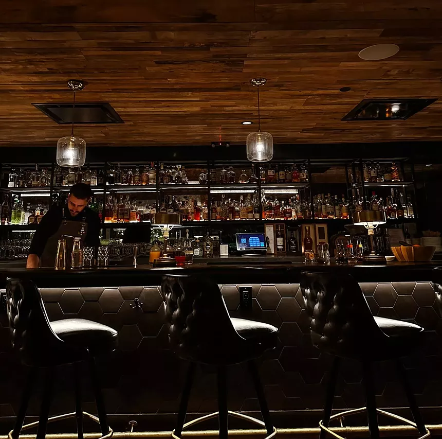 black chairs sit in front of a bar