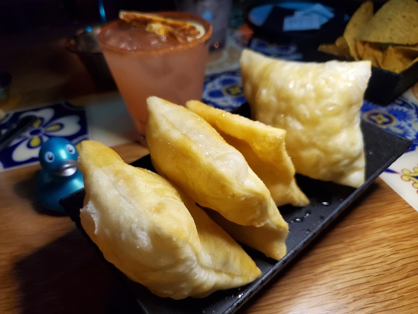 four sopaipillas on a plate