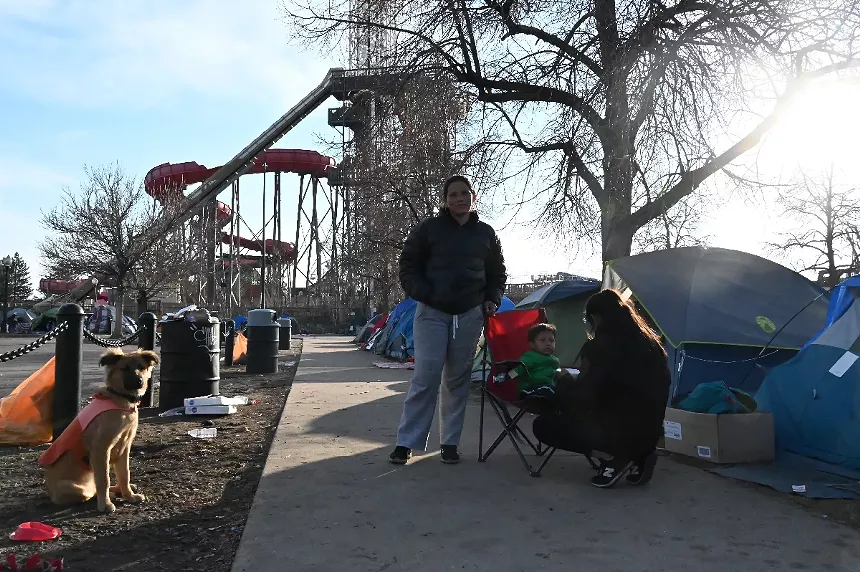 A migrant and her family stand outside Elitch Gardens.