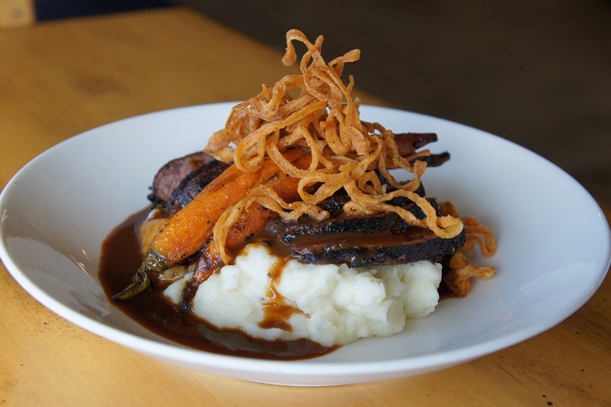 short ribs over mashed potatoes topped with carrots and crispy onions
