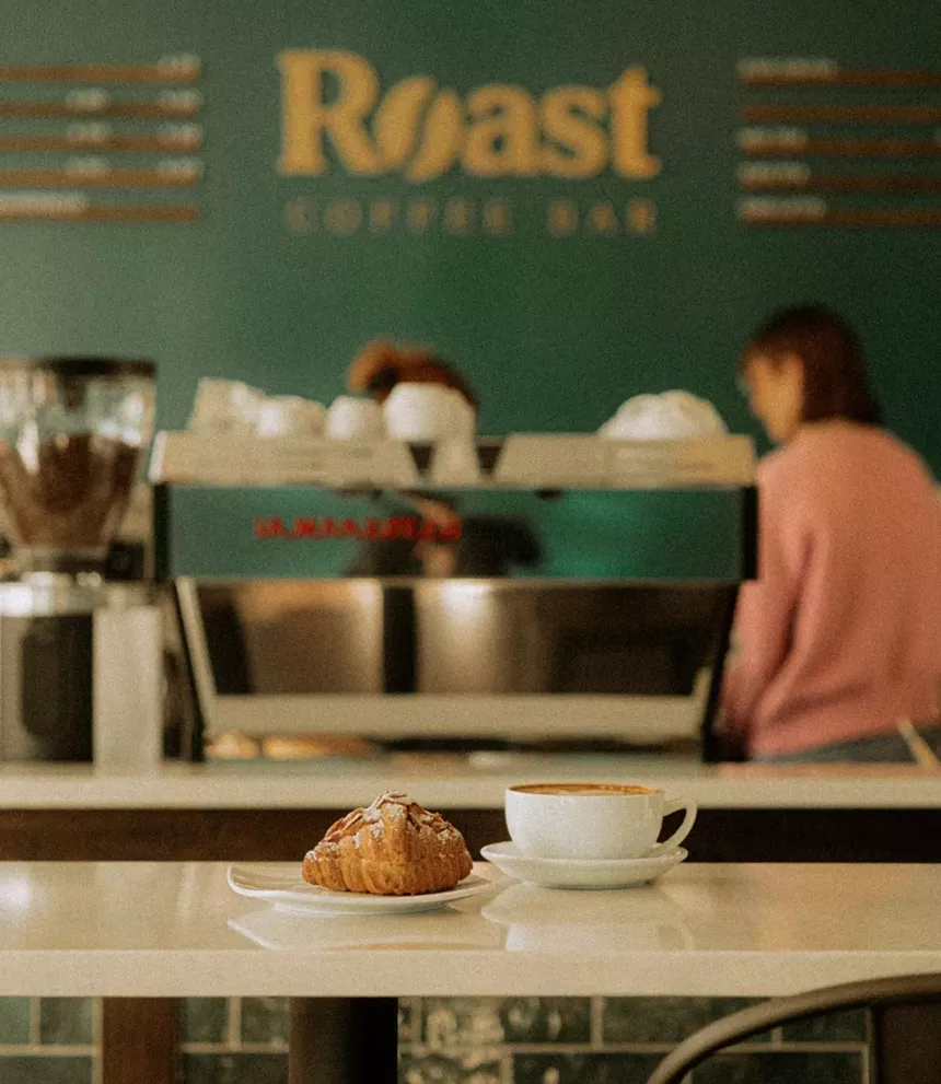 a pastry next to a cup of coffee