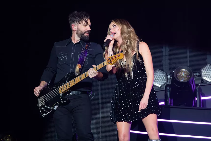woman singing next to a guitarist
