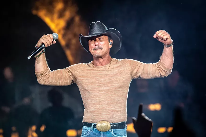 man in cowboy hat holding a microphone