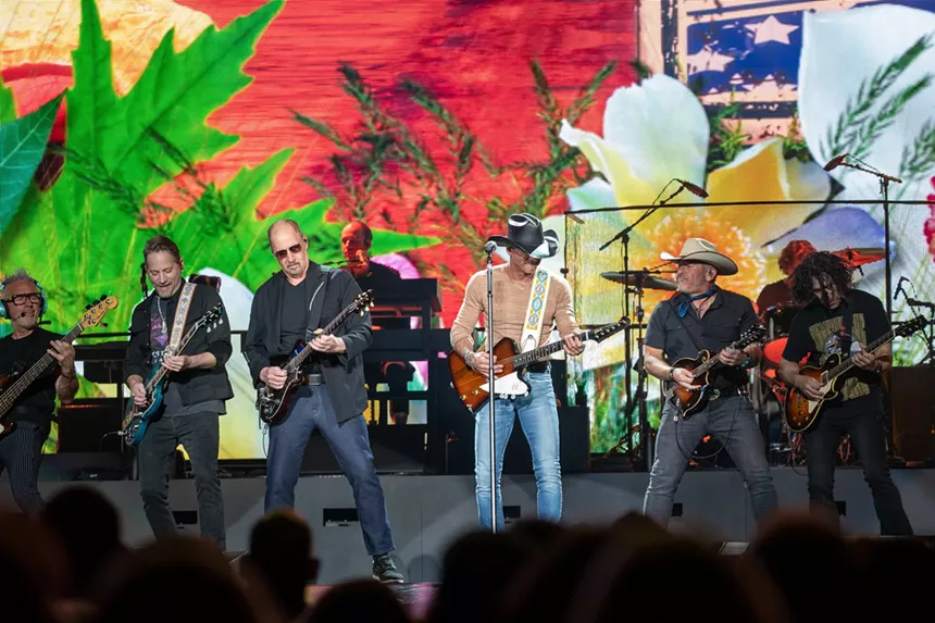 men in cowboy hats playing guitars on stage