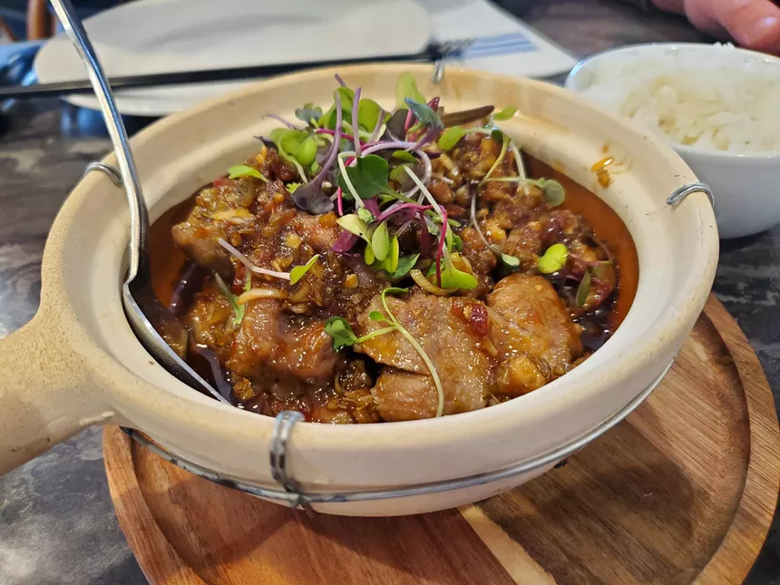 pork in a dark sauce served in a clay pot