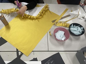 person cutting yellow paper