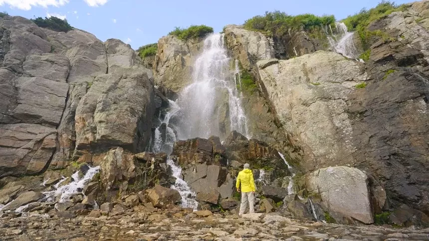 man standing in front of waterfall
