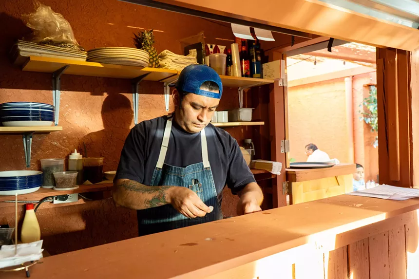 man in an apron behind a counter